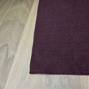 Corner-of-Aubergine-linen-placemat-on-wooden-table